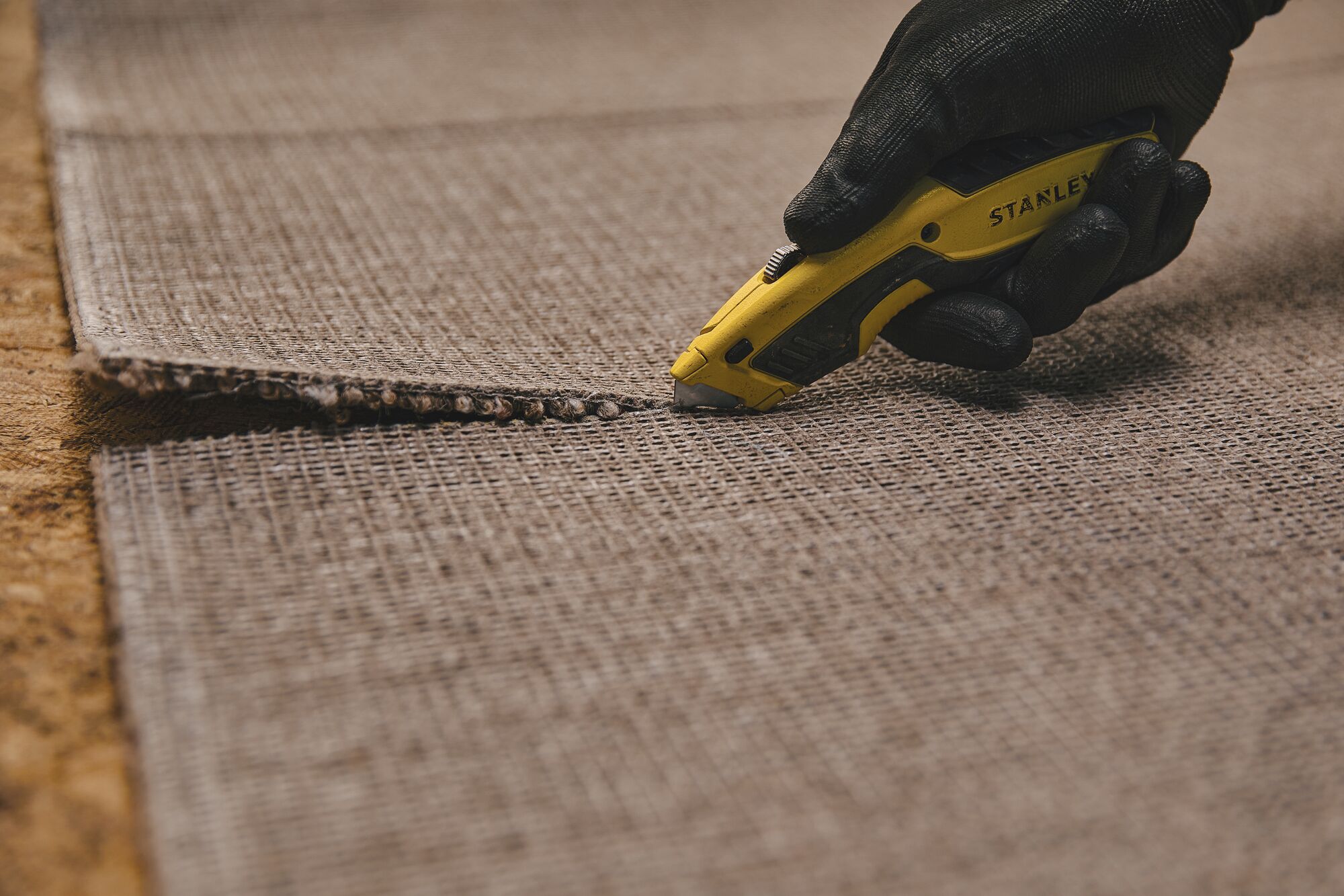 Retractable Utility Knife being used for cutting carpet.