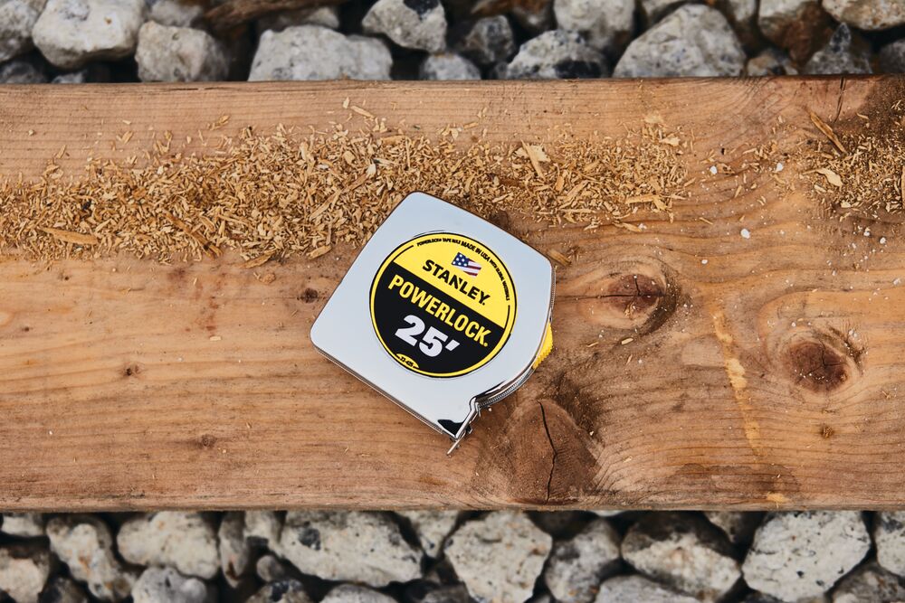 25 foot powerlock tape measure placed on wood plank outdoors.