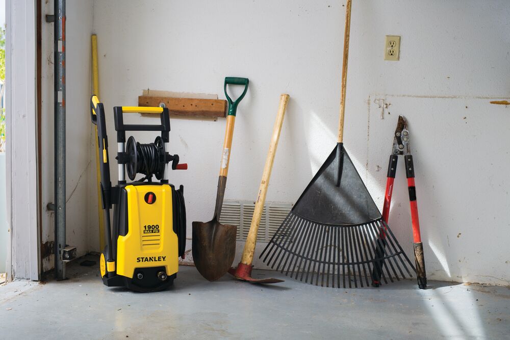 2150 P S I ELECTRIC PRESSURE WASHER placed with other tools in garage.