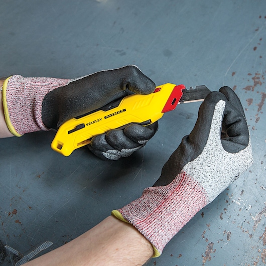 Fatmax left handed box top safety knife with its knife being pulled out.
