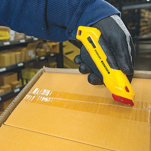 Fatmax left handed box top safety knife being used to cut a box.