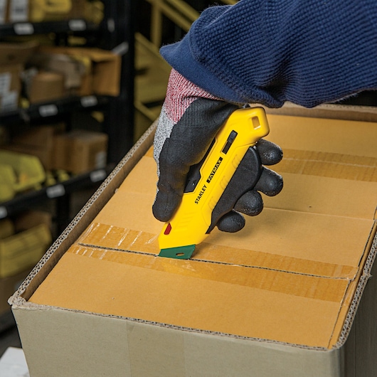 Fatmax right handed box top safety knife being used to cut a box.