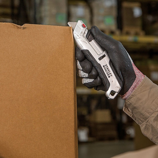 Fatmax premium auto retract tri slide safety knife being used to cut a box.