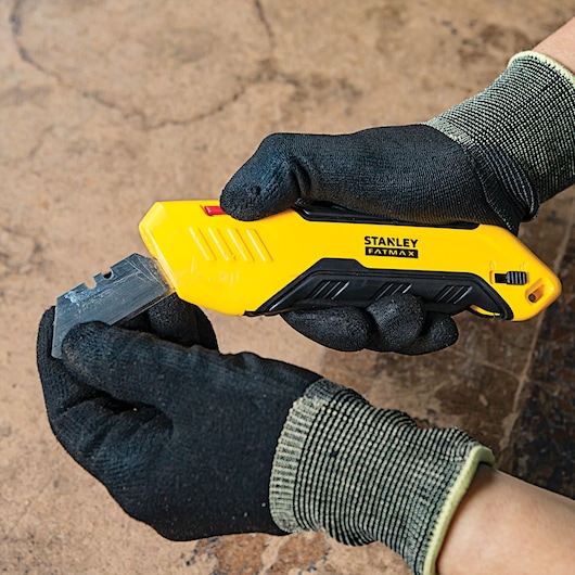 Fatmax auto retract squeeze safety knife being set with a replaceable head.
