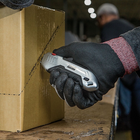 Fatmax premium auto retract squeeze safety knife being used to cut a box.