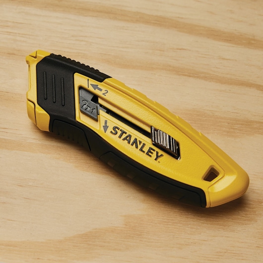 CONTROL GRIP RETRACTABLE UTILITY KNIFE placed on wooden panel.